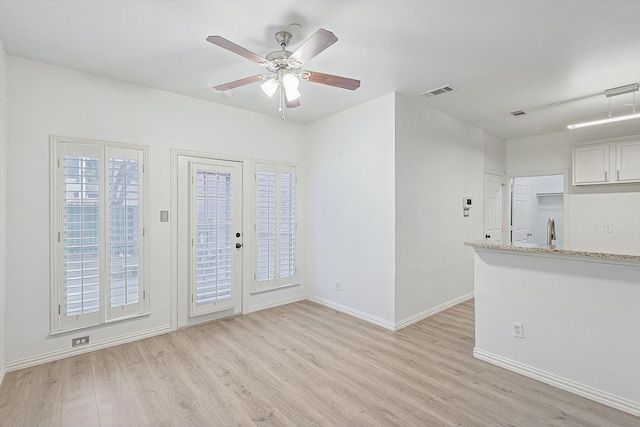 interior space featuring sink, ceiling fan, and light hardwood / wood-style flooring