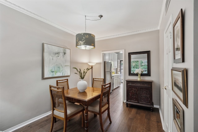 dining space featuring ornamental molding and dark hardwood / wood-style floors