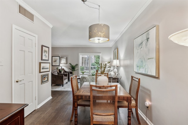 dining area featuring crown molding and dark hardwood / wood-style flooring