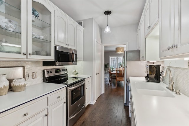 kitchen with sink, stainless steel appliances, decorative light fixtures, white cabinets, and dark hardwood / wood-style floors