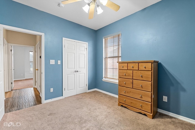 unfurnished bedroom with ceiling fan, carpet flooring, and a closet