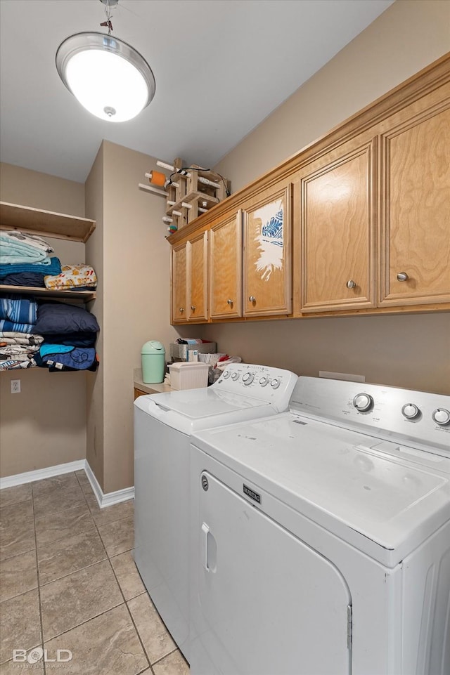 washroom featuring light tile patterned floors, cabinets, and washing machine and clothes dryer