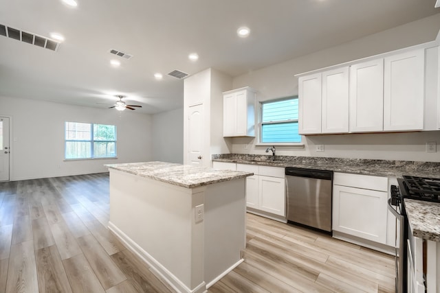 kitchen with light hardwood / wood-style floors, white cabinets, stainless steel appliances, and a kitchen island