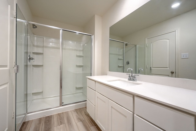 bathroom featuring vanity, hardwood / wood-style floors, and a shower with shower door