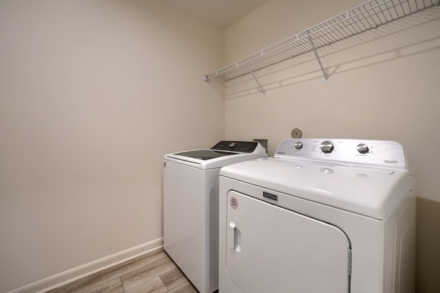 washroom featuring light hardwood / wood-style flooring and washer and clothes dryer