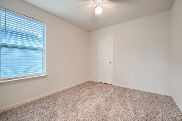 carpeted empty room with a wealth of natural light and ceiling fan