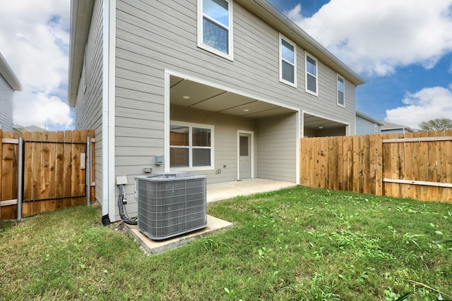 back of property featuring a patio area, cooling unit, and a yard