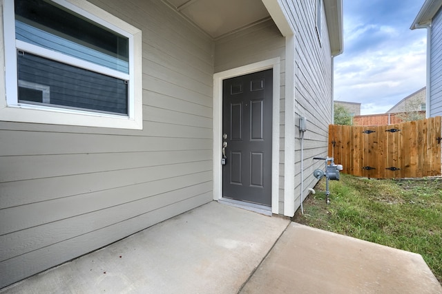 property entrance with a patio area and a lawn