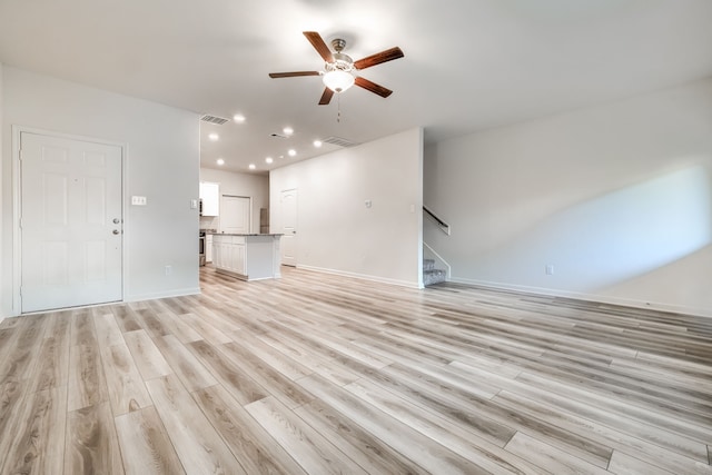 unfurnished living room featuring light wood-type flooring and ceiling fan