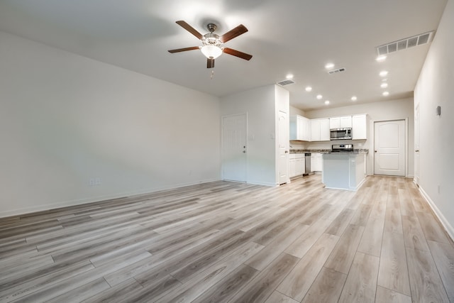 unfurnished living room featuring ceiling fan and light hardwood / wood-style flooring