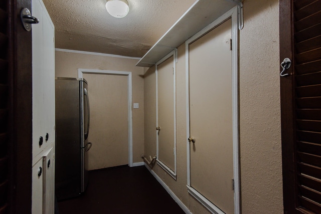 hall featuring ornamental molding and a textured ceiling