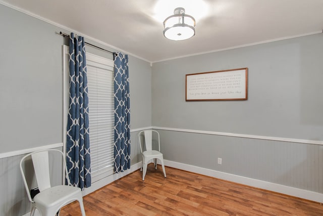 sitting room with hardwood / wood-style floors and crown molding