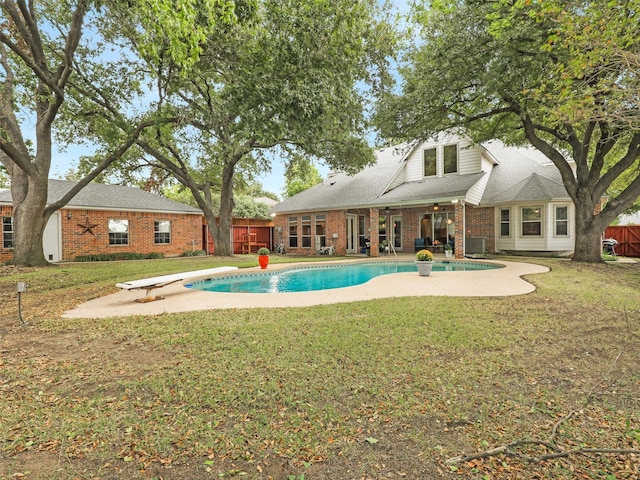 view of pool with a patio, a diving board, and a lawn