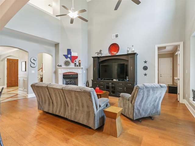 living room featuring hardwood / wood-style floors, a high ceiling, and ceiling fan