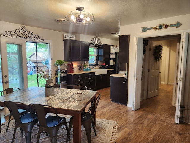 dining area featuring sink, hardwood / wood-style floors, and a textured ceiling