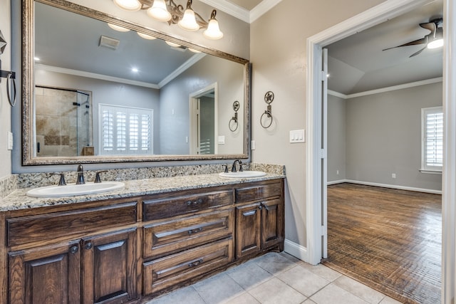 bathroom with ceiling fan, hardwood / wood-style flooring, tiled shower, vanity, and crown molding