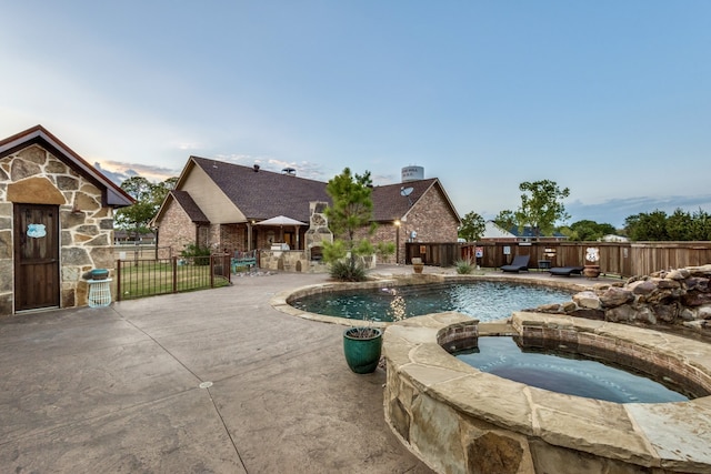 view of swimming pool featuring a patio area and an in ground hot tub