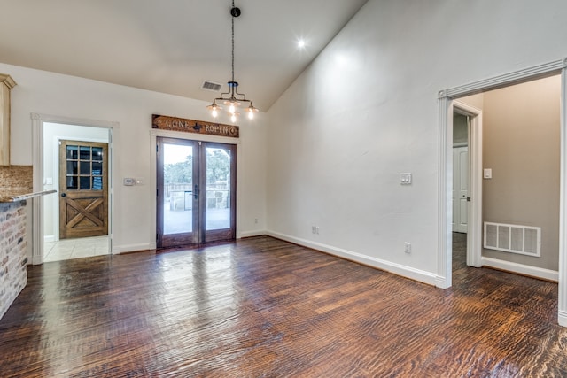 unfurnished dining area with french doors, high vaulted ceiling, and dark hardwood / wood-style flooring