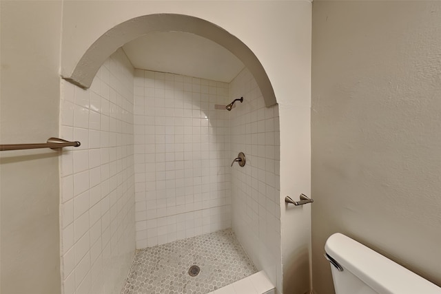 bathroom with toilet and tiled shower