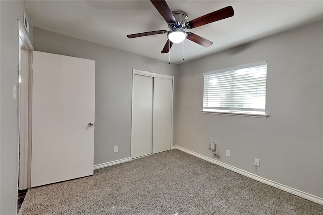 unfurnished bedroom with carpet, a closet, and ceiling fan