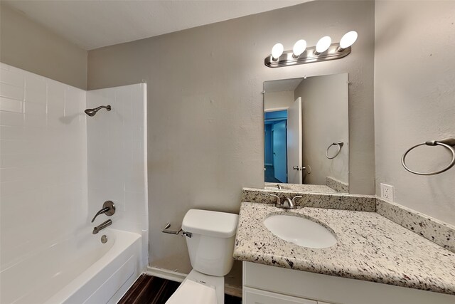 full bathroom featuring hardwood / wood-style floors, vanity, tub / shower combination, and toilet