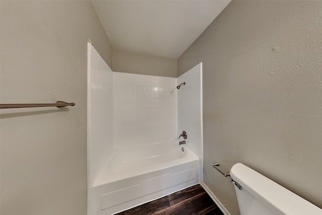 bathroom featuring hardwood / wood-style flooring, toilet, and tiled shower / bath