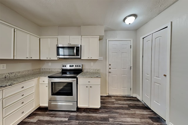 kitchen featuring white cabinets, dark hardwood / wood-style floors, light stone counters, and stainless steel appliances