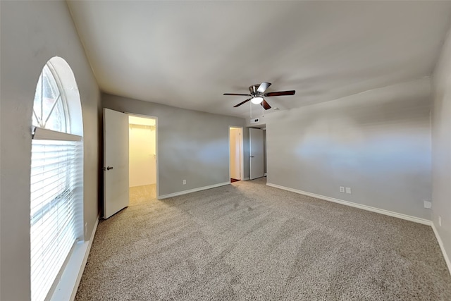 carpeted spare room featuring ceiling fan