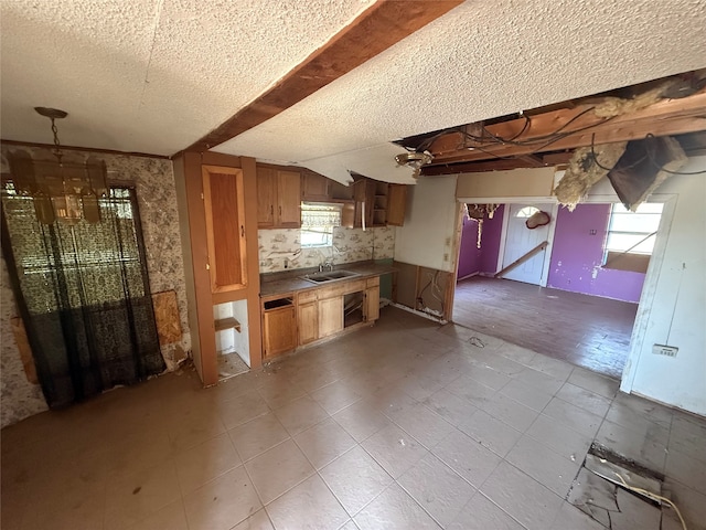 kitchen with decorative backsplash, a textured ceiling, sink, and a wealth of natural light