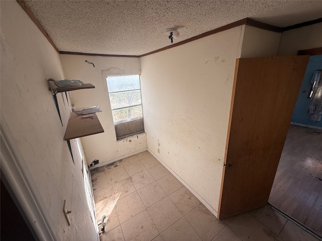 unfurnished room featuring crown molding and a textured ceiling