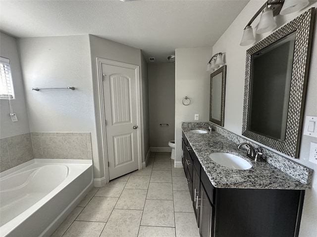 bathroom with a textured ceiling, toilet, a bath, vanity, and tile patterned flooring