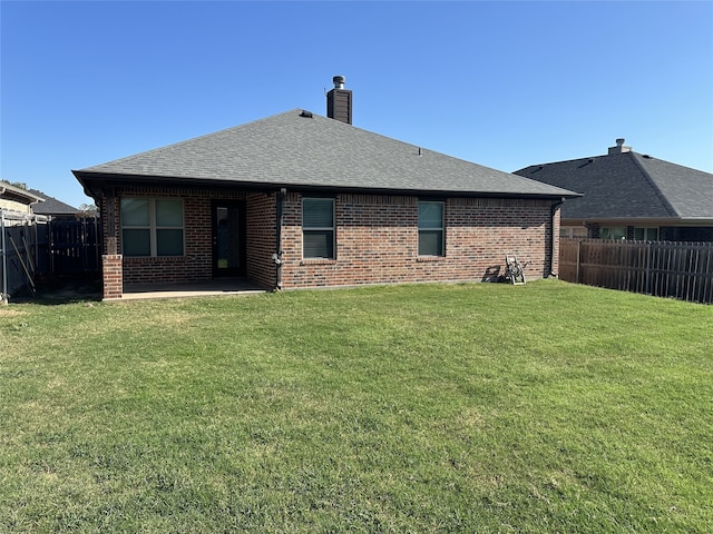 back of house featuring a patio area and a lawn