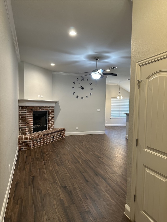 unfurnished living room featuring ornamental molding, ceiling fan, a brick fireplace, and dark hardwood / wood-style flooring