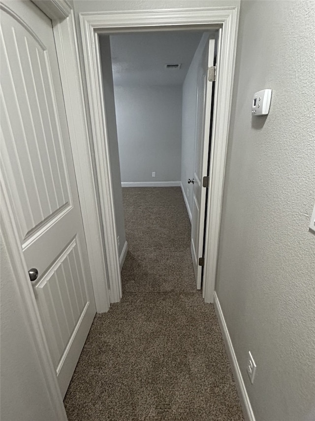 hallway featuring dark carpet