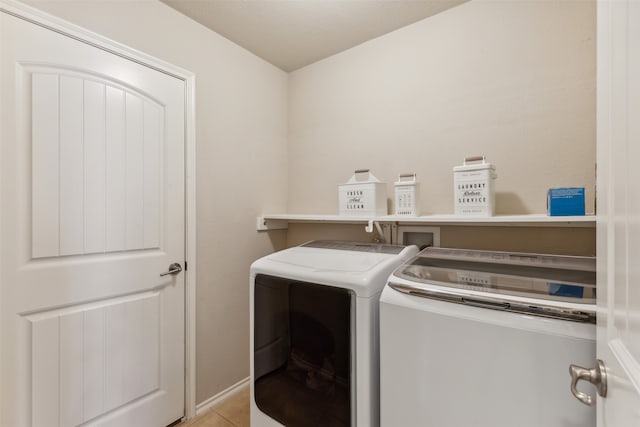 washroom featuring light tile patterned flooring and washer and dryer