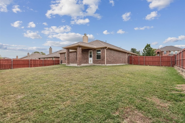 back of house featuring a patio area and a lawn