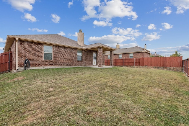 rear view of house featuring a patio area and a lawn