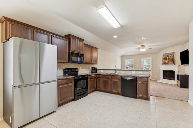 kitchen featuring sink, ceiling fan, backsplash, black appliances, and dark stone counters