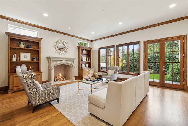 living room with french doors, light wood-type flooring, and crown molding