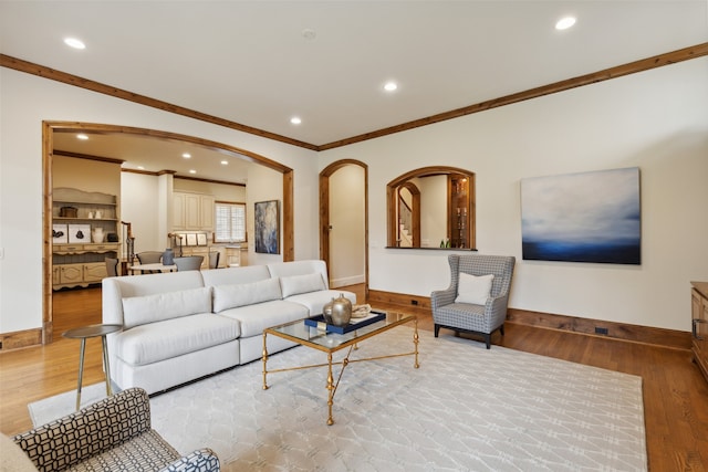 living room featuring light wood-type flooring and crown molding