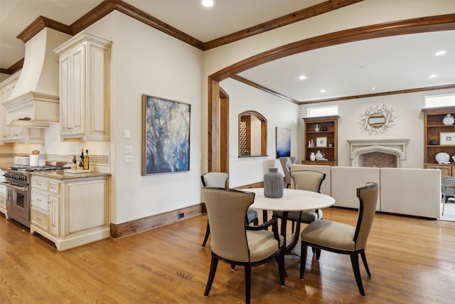 dining area with light hardwood / wood-style floors and ornamental molding