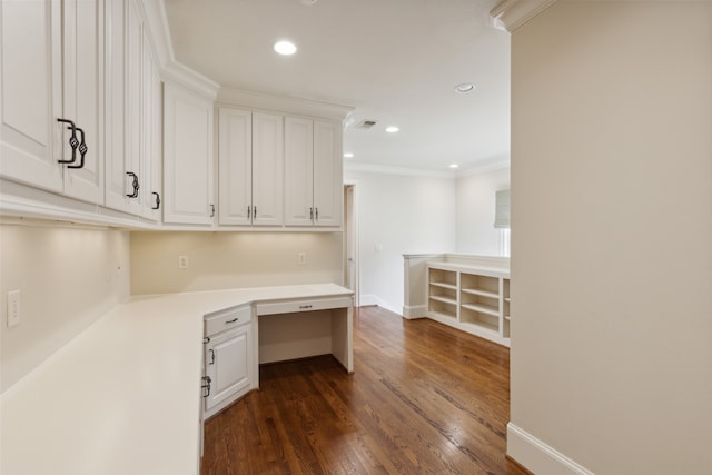 unfurnished office featuring ornamental molding, dark hardwood / wood-style flooring, and built in desk