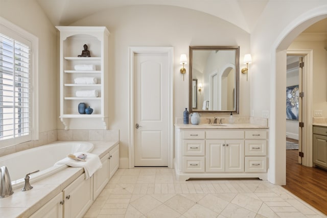 bathroom with a bathtub, vanity, lofted ceiling, and hardwood / wood-style floors