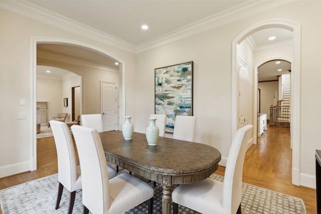 dining space featuring wood-type flooring and crown molding