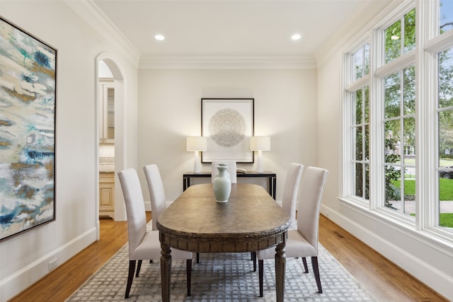 dining space with wood-type flooring and crown molding