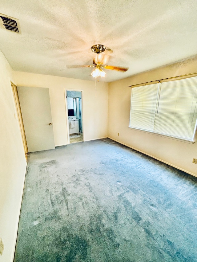 carpeted spare room featuring a textured ceiling and ceiling fan