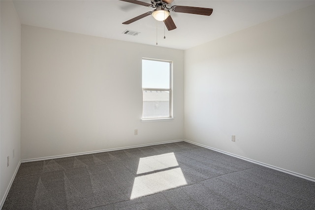 spare room featuring dark carpet and ceiling fan