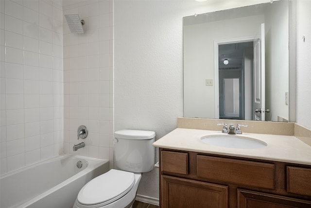 full bathroom featuring vanity, tiled shower / bath combo, and toilet