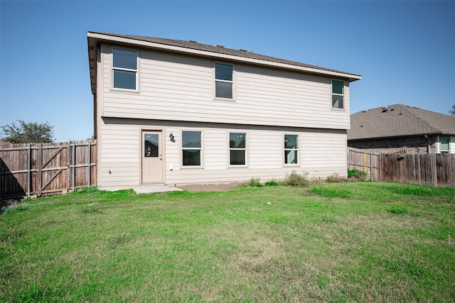 rear view of property featuring a yard