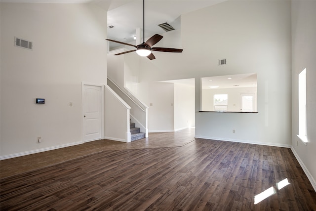 unfurnished living room featuring dark hardwood / wood-style floors, a healthy amount of sunlight, high vaulted ceiling, and ceiling fan